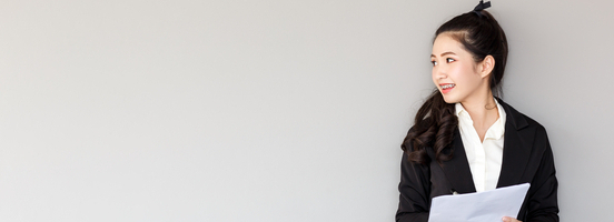 A graduate student standing against a wall