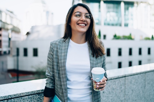 Une femme cadre sur la terrasse de son entreprise en Auvergne-Rhône-Alpes, dégustant un café. 