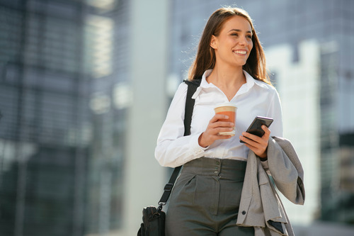 A businesswoman smiling and looking away thinking about her employee benefits