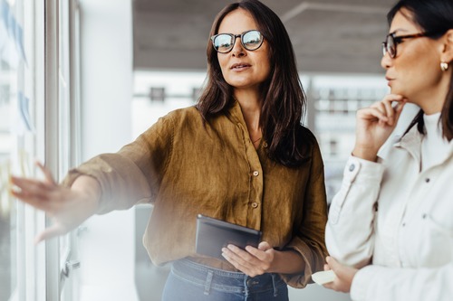 Two businesswomen talking about employee engagement and loyalty 