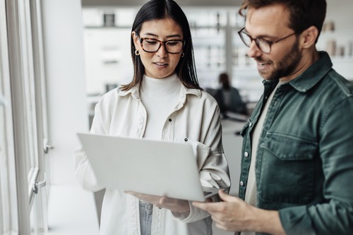 two people looking at a laptop